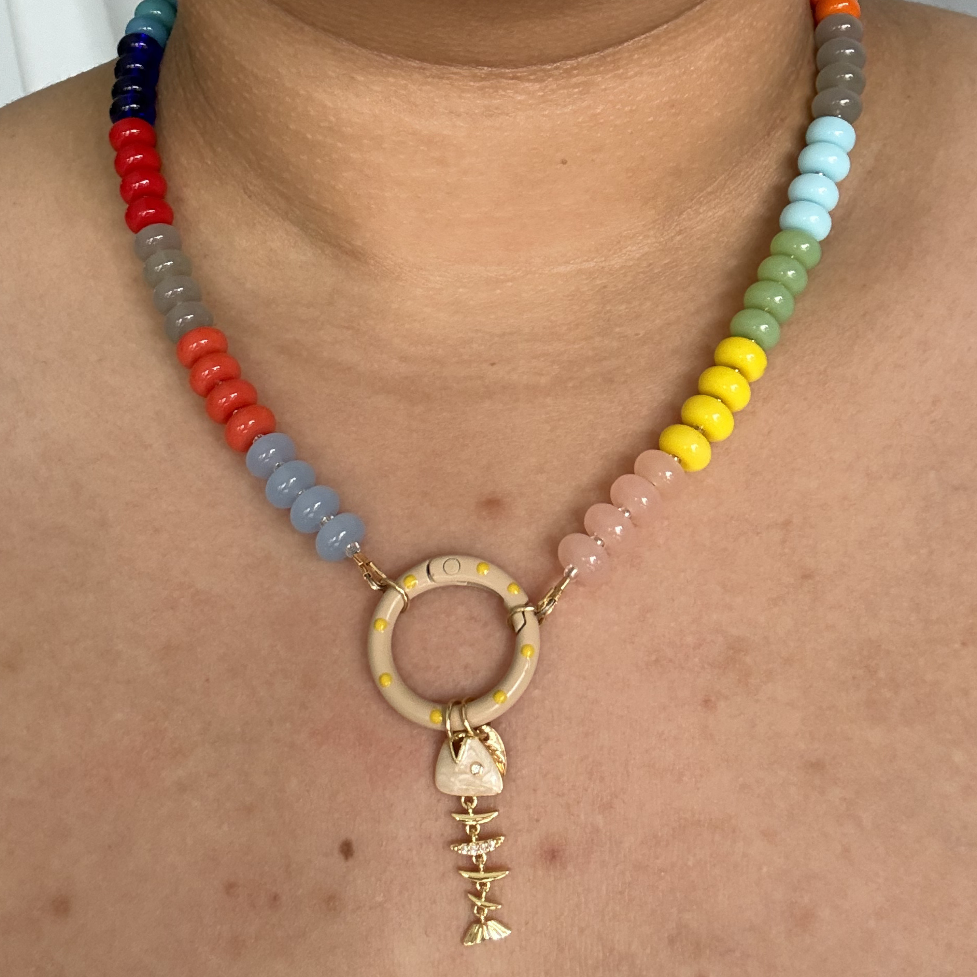 Collar de piedras en colores con cierre en círculo y dije de pez